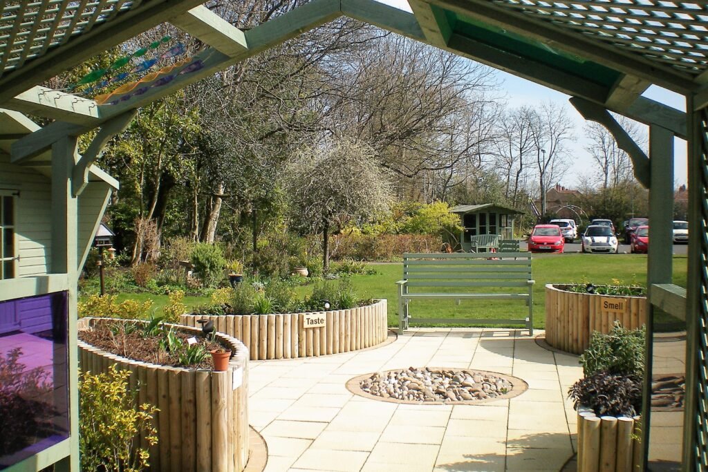 Courtyard garden with a pergola and seating at St Cuthbert's Hospice, Durham