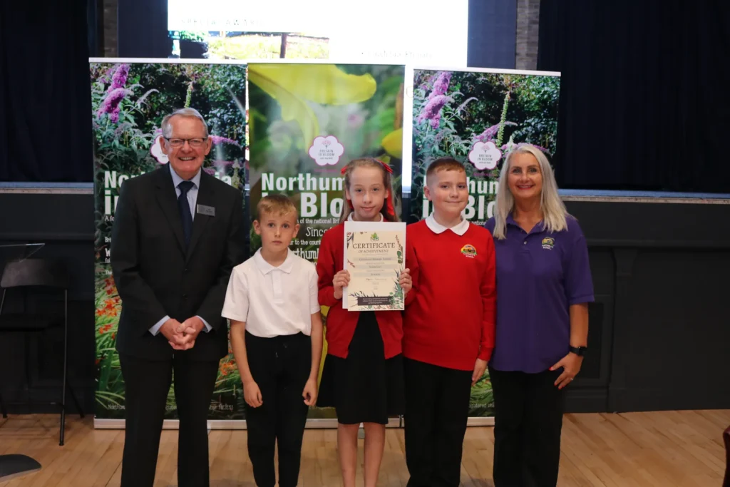 Schoolchildren receiving their certificate on stage at the 2026 presentation of awards